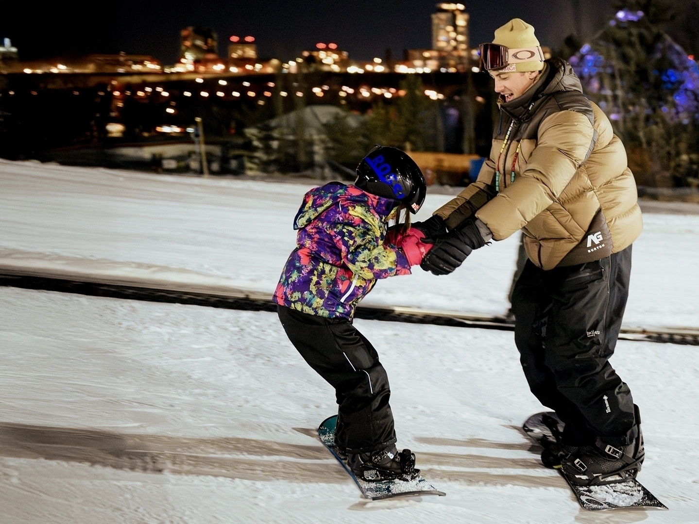 a man helping a child snowboard